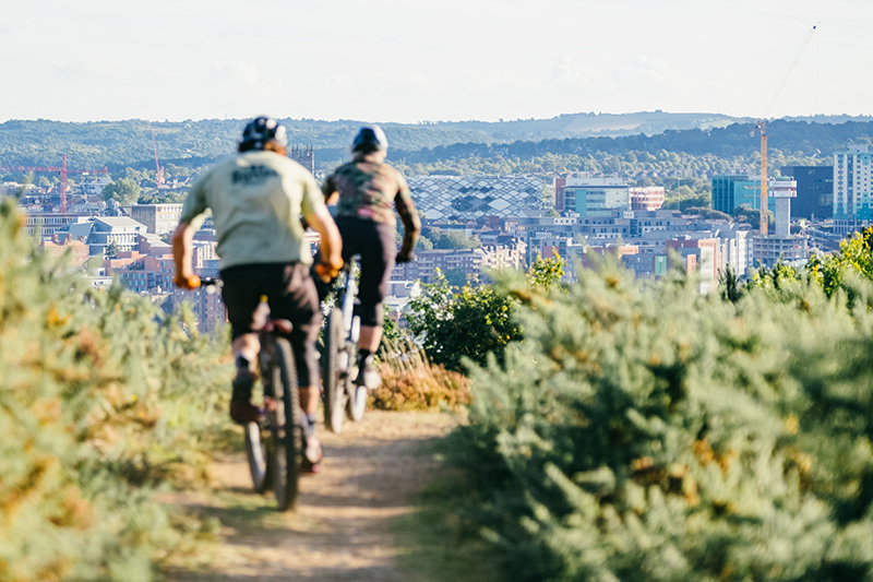 Mountain bikers cycling towards the city