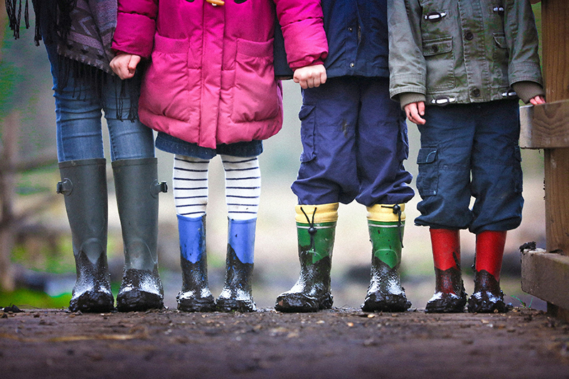 Row of children's legs in different coloured wellies