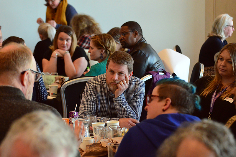 People sat round tables at a community meeting